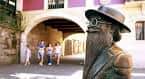 Estatua de un personaje ilustre en un pasaje con arcos del casco antiguo