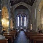 Nave central de la Iglesia de San Francisco con bancos de madera y arcos góticos