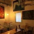 Rincón del comedor con obras de arte en las paredes y mobiliario de madera