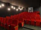 Sala de cine NUMAX vacía con butacas rojas y pantalla