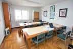 Aula o sala de reuniones con mesas y sillas dispuestas para clases o eventos