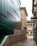 Detalle de la fachada moderna del Museo de las Peregrinaciones junto a la arquitectura histórica