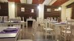 Interior del comedor del Restaurante Tapas Areal con mesas y sillas blancas