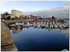 Puerto de Curuxeiras con embarcaciones y edificios bajo un cielo nublado