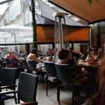 Terraza exterior de un café o restaurante con mesas y sombrillas