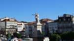 Estatua en la Praza dos Irmáns García Naveira con edificios al fondo