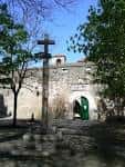 Cruz de piedra en el centro de la Plaza Santa Bárbara bajo un cielo azul