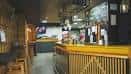 Interior de Bar Argallo con barra de madera y taburetes
