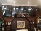 Detalle de la barra del bar con botellas y espejo en el Café Latino