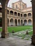 Patio interior con césped y arquerías en el Colexio de Fonseca