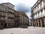 Amplia vista de la Praza de Cervantes con la fuente y los edificios porticados.
