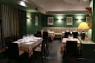 Interior de restaurante con mesas preparadas y paredes verdes