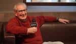 Hombre sonriente en una entrevista o conversación en un sofá