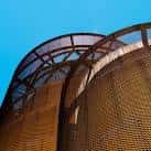 Vista de dos estructuras cilíndricas de acero corten con techos perforados