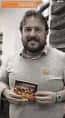Hombre sonriendo y mostrando un libro en la Libraría Cartabón