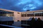 Fachada de la Facultad de ADE al atardecer con grandes ventanales