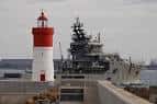 Buque Carnota (A-61) pasando junto a un faro rojo en A Coruña