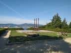 Monumento en un área verde del parque con vistas al mar.