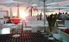 Ambiente de chiringuito al atardecer con cóctel en primer plano