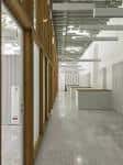 Pasillo interior de galería con estructura de madera y suelo de hormigón