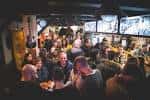 Interior del Creedence Rock Bar con ambiente animado y gente en la barra
