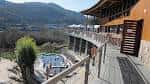 Perspectiva del edificio principal y las piscinas desde la terraza de madera