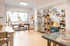Interior luminoso de un estudio de arte con mesas y estanterías