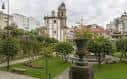 Jardín público con iglesia histórica y fuente decorativa