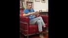 Hombre sentado en un sillón rojo durante una presentación de libro en la librería