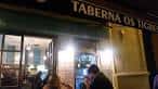 Fachada iluminada de la Taberna Os Tigres por la noche