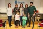 Grupo de personas y niños en un salón interior, posiblemente para un evento o ceremonia.