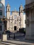 Perspectiva de la Iglesia de San Nicolás desde la calle, enmarcada por arquitectura urbana.