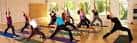 Clase de yoga en progreso con varias personas realizando posturas