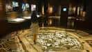 Persona caminando sobre un mapa del castro proyectado en el suelo del museo