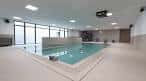 Piscina cubierta con ventanales y zona de acceso