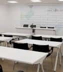 Sala de reuniones o formación con mesas y sillas dispuestas para un evento