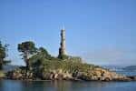 Primer plano del faro de la Illa de Tambo en la costa rocosa