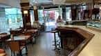 Amplio interior de una cafetería con barra y mesas en Vigo
