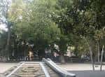Área de juegos infantiles rodeada de árboles en la Plaza de España