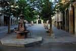 Vista de la Plaza de la Verdura al atardecer, destacando la fuente central y los árboles