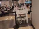 Zona de cafetería con mesas y carrito de servicio