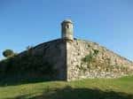 Vista de la muralla del Castillo de San Sebastián con garita y cielo azul