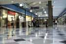 Pasillo interior del centro comercial con tiendas a los lados y suelo pulido