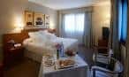 Habitación doble del hotel con cama grande y servicio de desayuno en la mesa