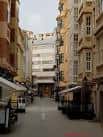 Vista de una calle peatonal con edificios y toldos en A Coruña