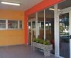 Detalle de la entrada acristalada del CEIP Francisco Vales Villamarín con jardineras