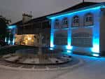 Fachada del Hotel O'Pazo iluminada con luces azules por la noche.