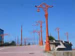 Sección del Paseo Marítimo de A Coruña con sus distintivas farolas rojas bajo un cielo azul