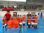 Pista polideportiva interior con niños practicando fútbol sala