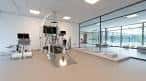 Sala de rehabilitación con equipos médicos y grandes ventanales